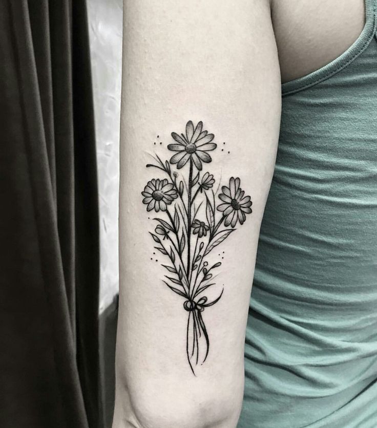 Daisy tattoo on the shoulder for women