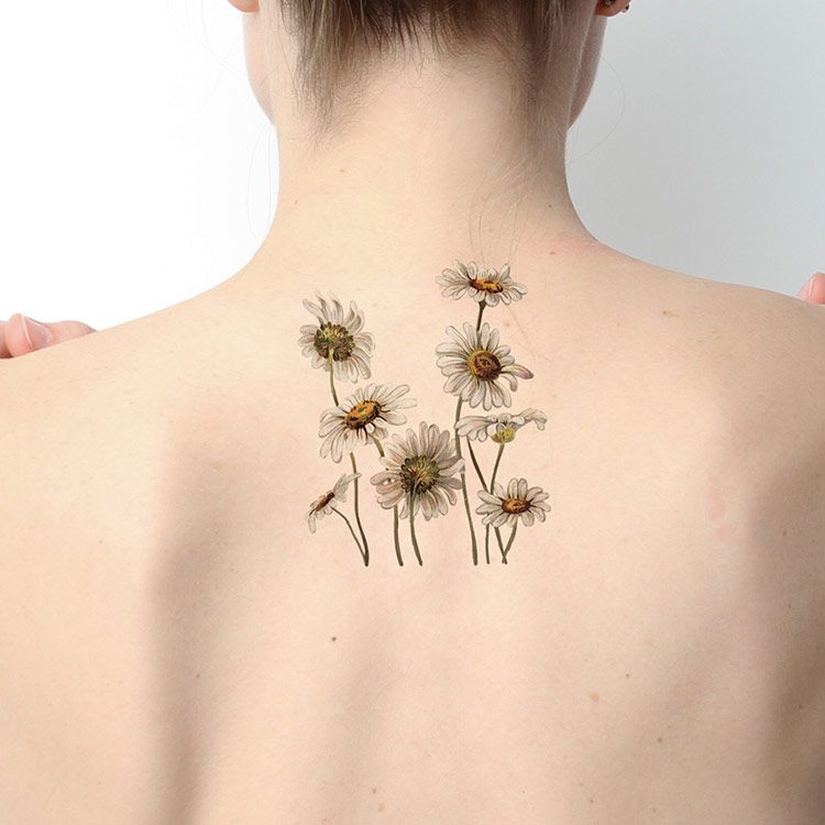 Colorful daisy tattoo on the back for women