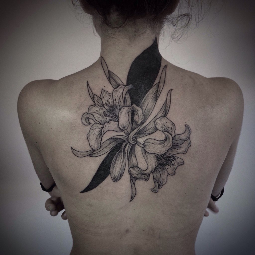 Large lily tattoo on the back for women