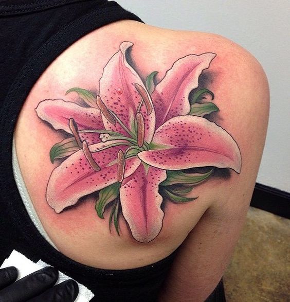 Large lily tattoo on the shoulder blade for women