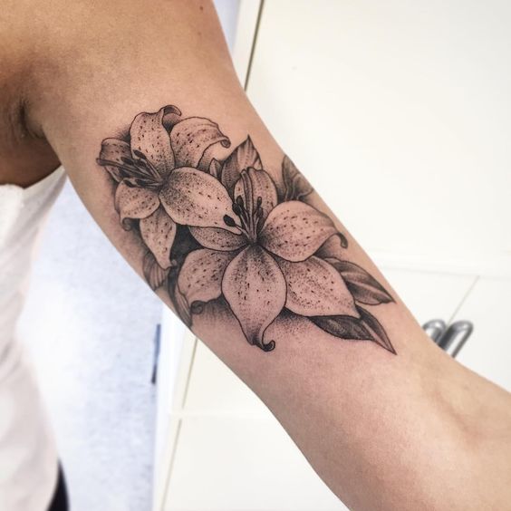 Tattoo of two lilies on the shoulder for men