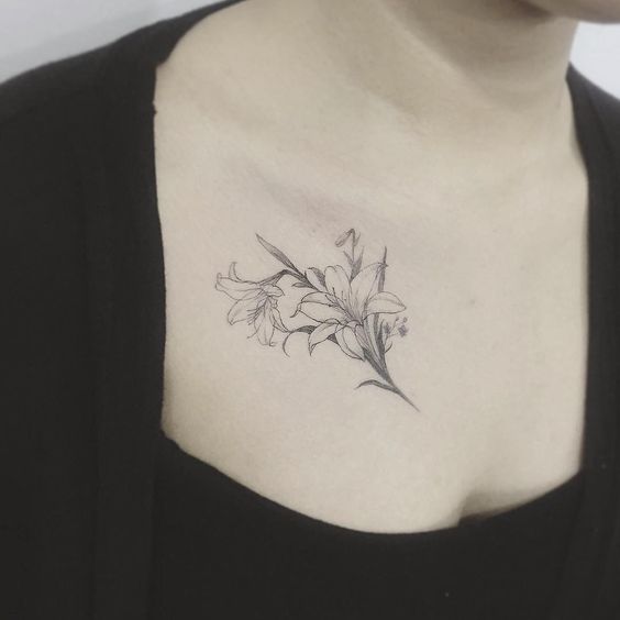 Tattoo of two lilies on the collarbone for women