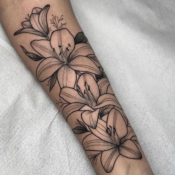 Tattoo of four lilies on the forearm for women