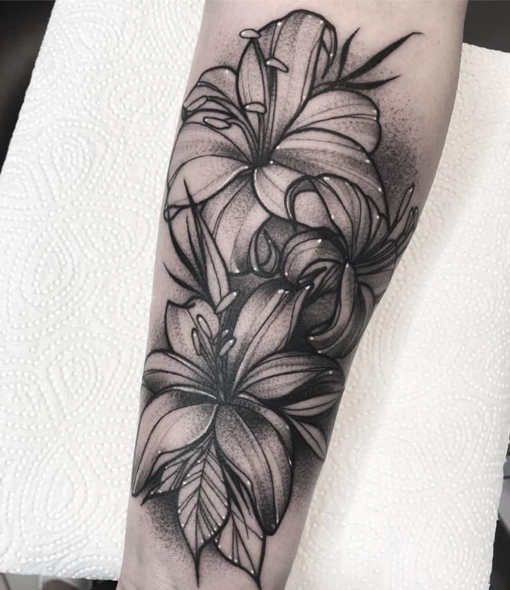 Tattoo of three lilies on the arm for women