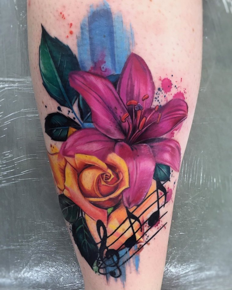 Colorful tattoo of lilies and roses on the shin for women