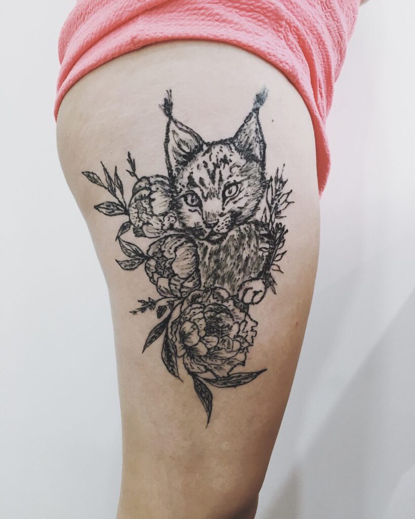 Tattoo of a colored lynx on the hip for women