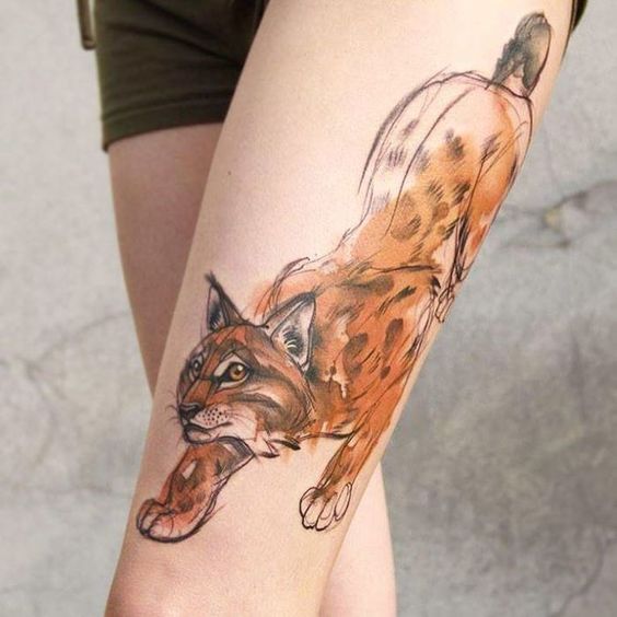 Tattoo of a colored lynx on the hip for women