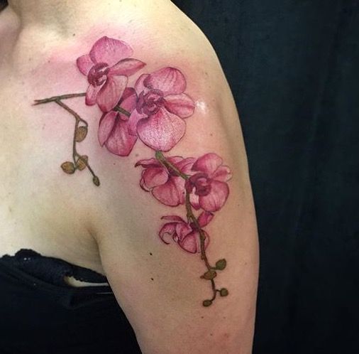 Color tattoo of an orchid on the shoulder for women