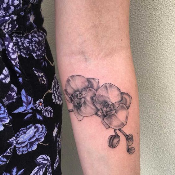 Large orchid tattoo on the forearm for women