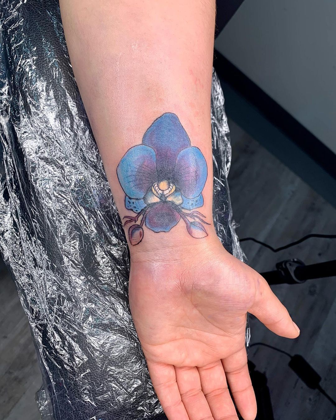 Color orchid tattoo on the wrist for women