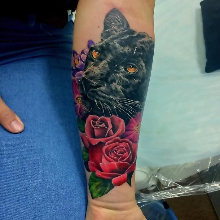 Colored panther tattoo on the forearm for women