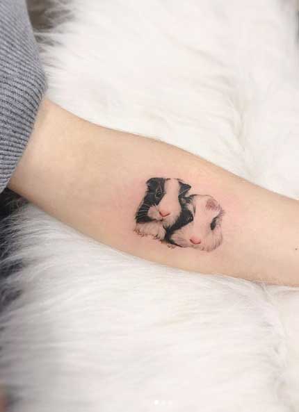 Tattoo of two guinea pigs on the forearm for women