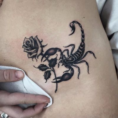 Tattoo of a scorpion with a rose on her stomach for women