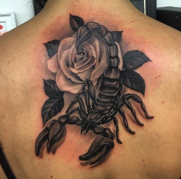 Tattoo of a scorpion with a rose on his back for men