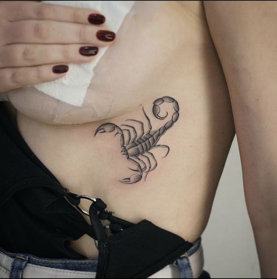 Tattoo of a scorpion on the stomach for women