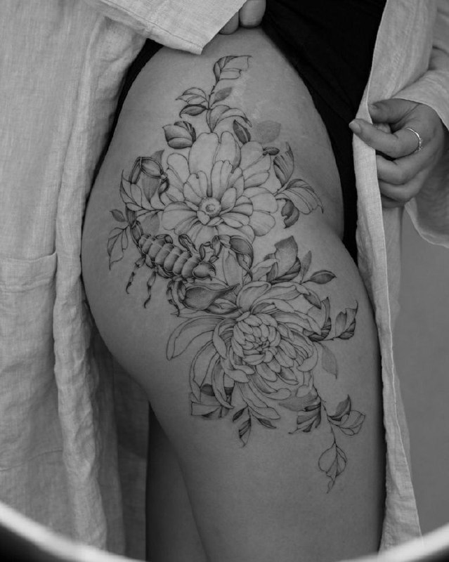 Scorpion tattoo with flowers on the thigh for women