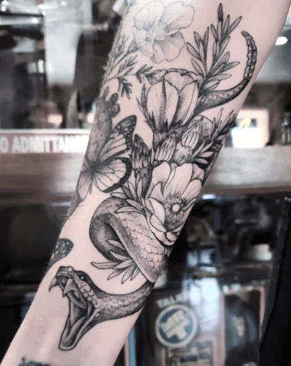 Tattoo of a large rattlesnake on the arm for women