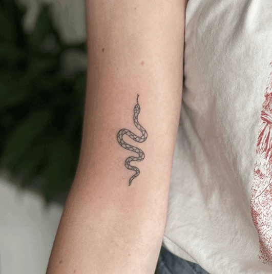 Tattoo of a small snake on the shoulder for women