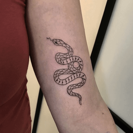 Tattoo of a small snake on the shoulder for women