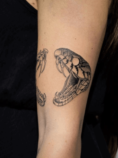 Snake head tattoo on the shoulder for women