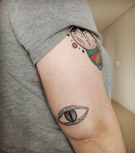 Snake eye tattoo on the shoulder for women