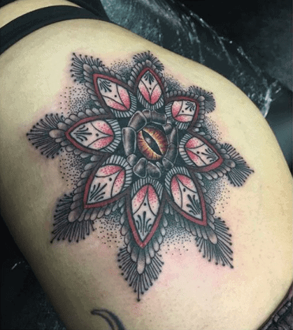 Snake eye tattoo on the thigh for women
