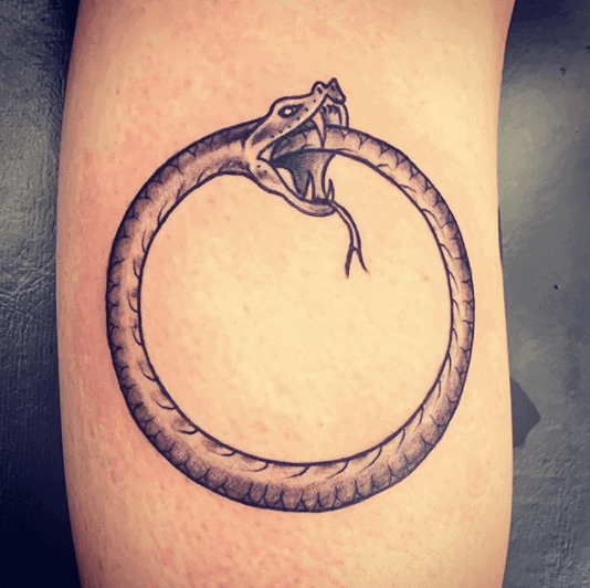 Ouroboros tattoo on the shin for men