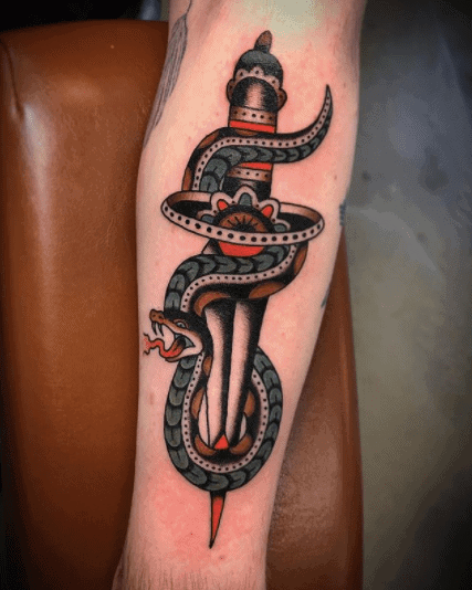 Snake and dagger tattoo on forearm for men