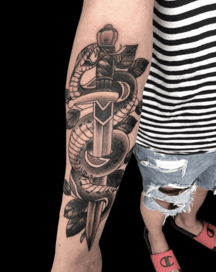 Snake and dagger tattoo on forearm for women