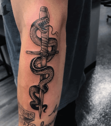 Snake and dagger tattoo on the forearm for men