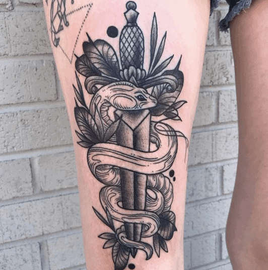 Snake and dagger tattoo on the thigh for women