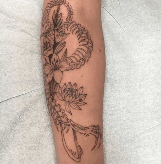 Snake skeleton tattoo on forearm for women