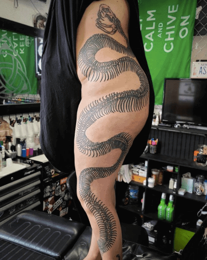 Snake skeleton tattoo on the leg for women