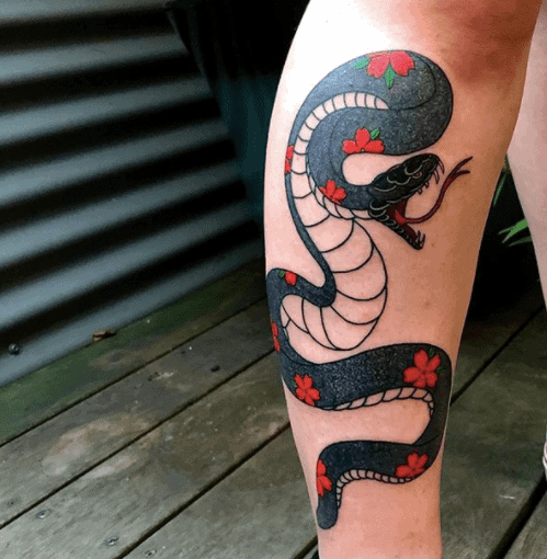 Tattoo of a colored snake on the lower leg for women