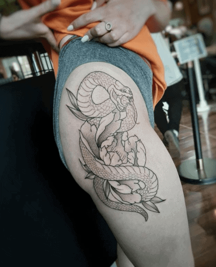 Snake tattoo on the thigh for women