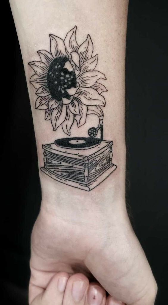 Large sunflower tattoo on the forearm for women