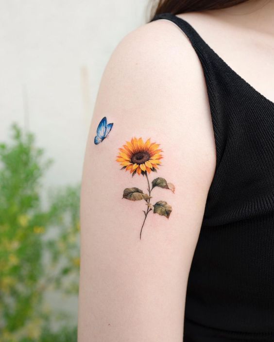 Sunflower tattoo with a butterfly on the shoulder for women