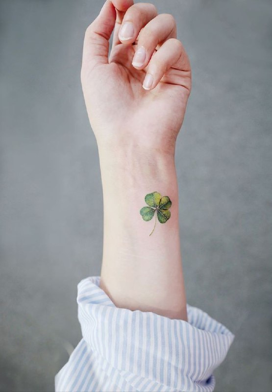 Colored clover tattoo on the forearm for women