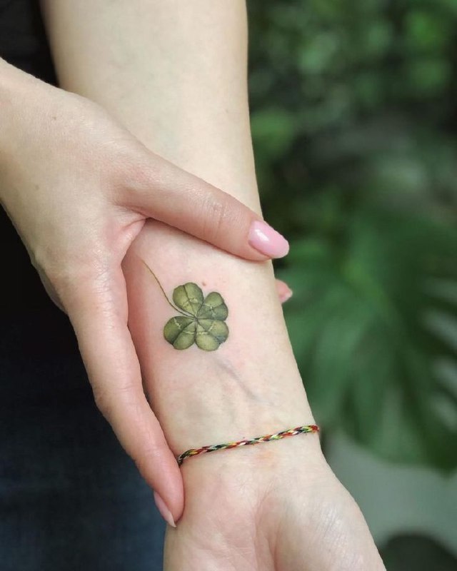 Colored clover tattoo on the forearm for women