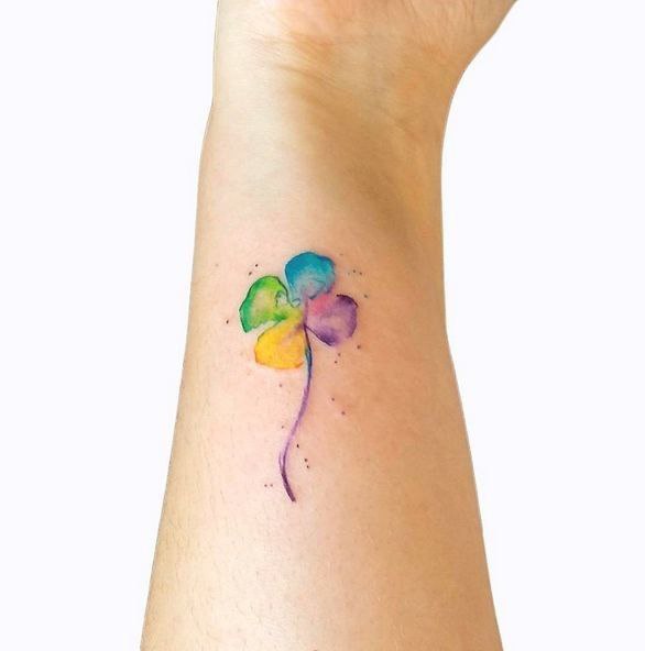 Colored clover tattoo on the forearm for women