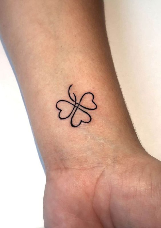 Tattoo of a clover on the forearm for women