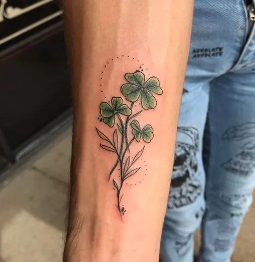 Colored clover tattoo on the forearm for women