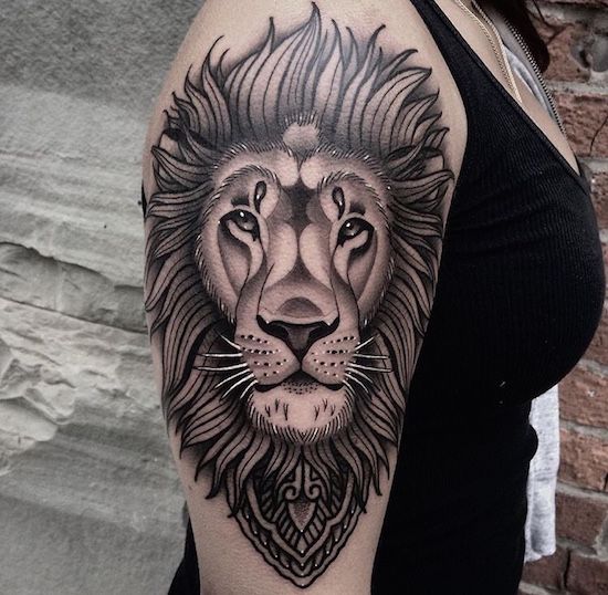 Tattoo of a lion on the shoulder for women