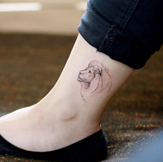 Tattoo of a lion on the shin for women