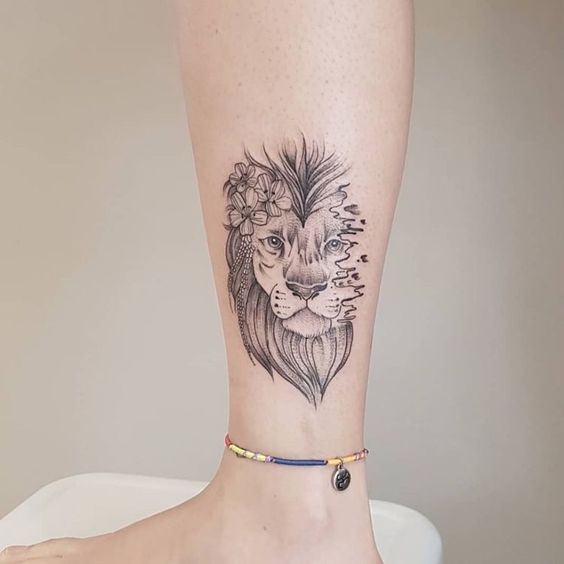 Tattoo of a lion on the shin for women