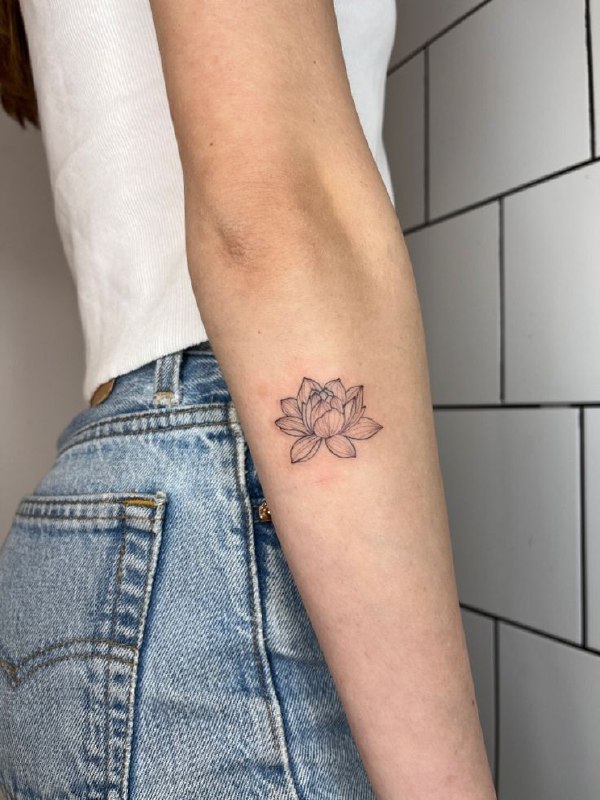 Small lotus tattoo on the forearm for women