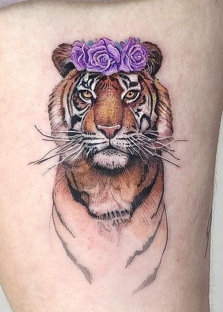 Color tattoo of a tiger on the hip for women