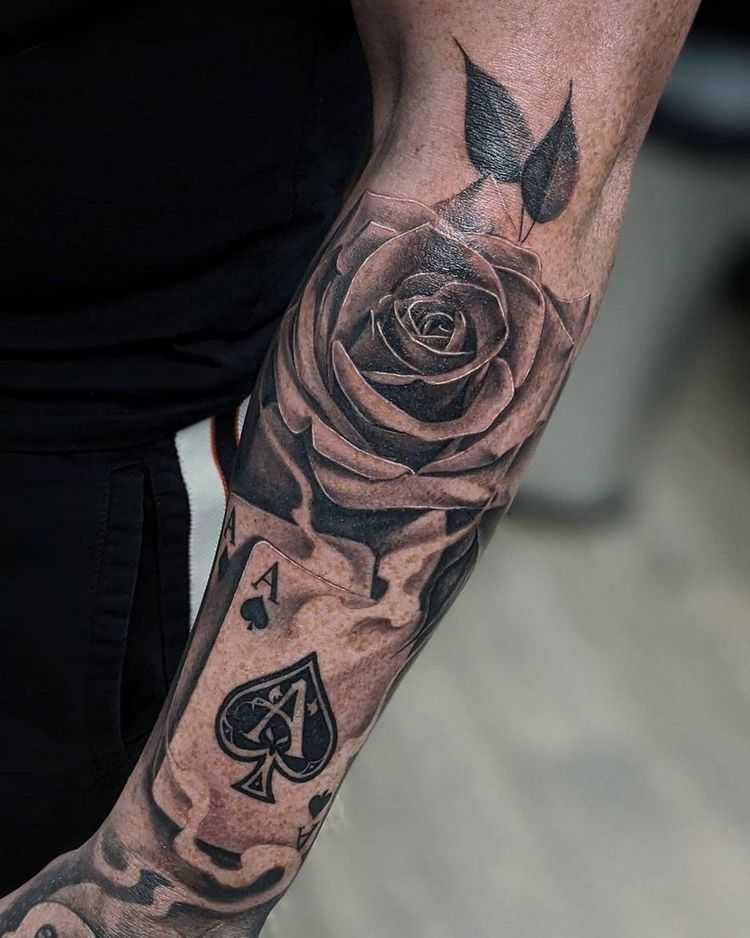 Large rose tattoo with cards on the forearm for men