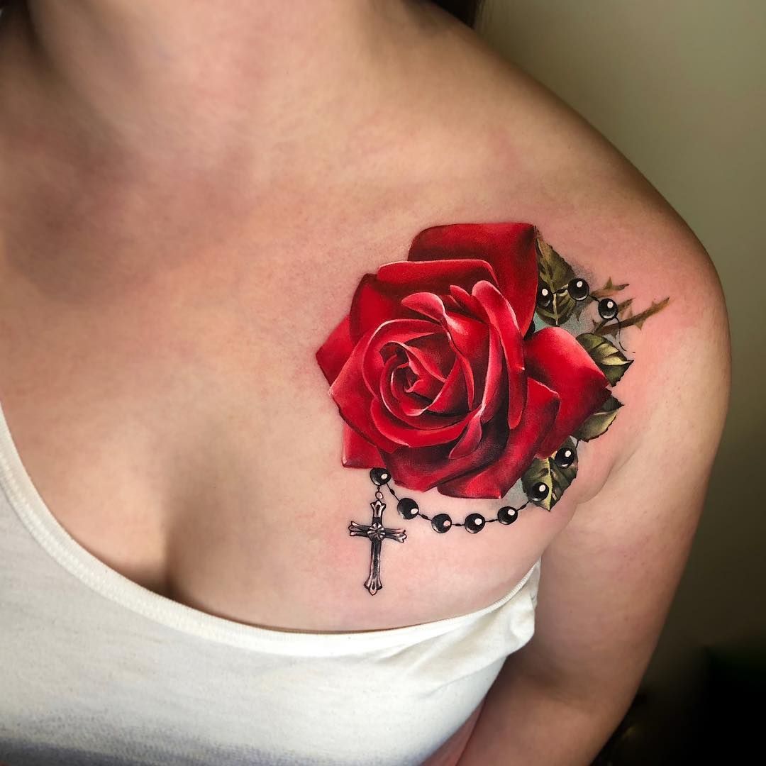 Colorful rose tattoo with a cross on the shoulder for women