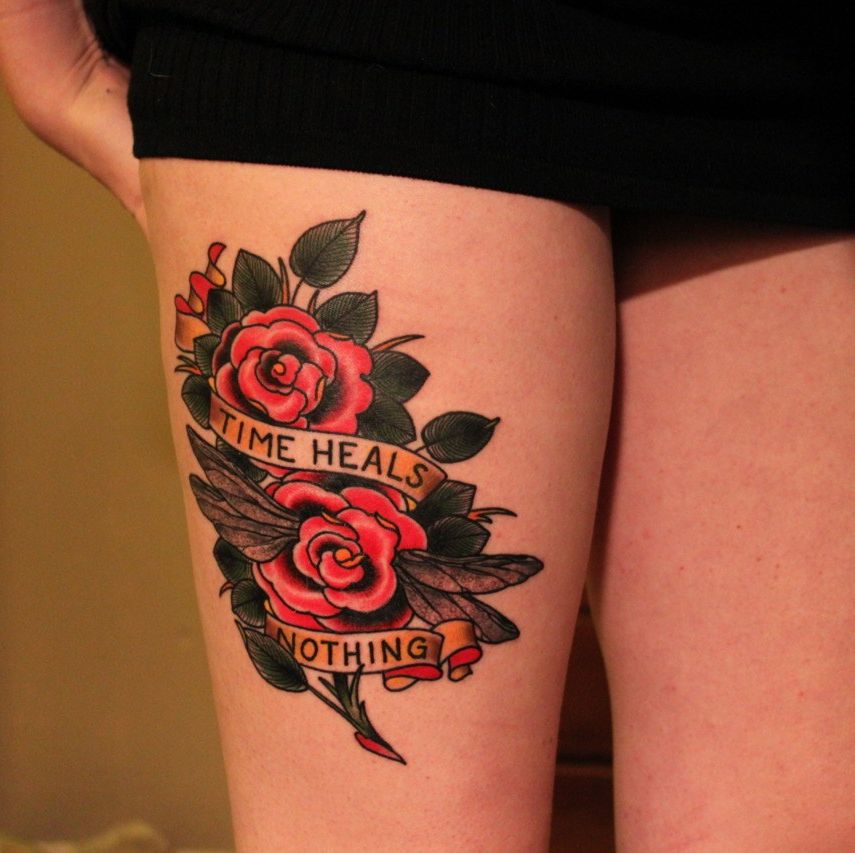 Colorful rose tattoo with inscription on the hip for women